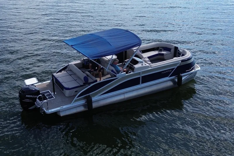 Slide: The Image of 2022 Harris Grand Mariner 250 pontoon boat on water with blue canopy. - 17