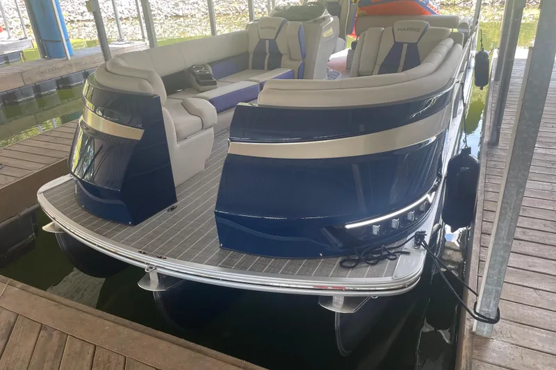Slide: The Image of 2022 Harris Grand Mariner 250 pontoon boat docked, featuring spacious seating and sleek design. - 5