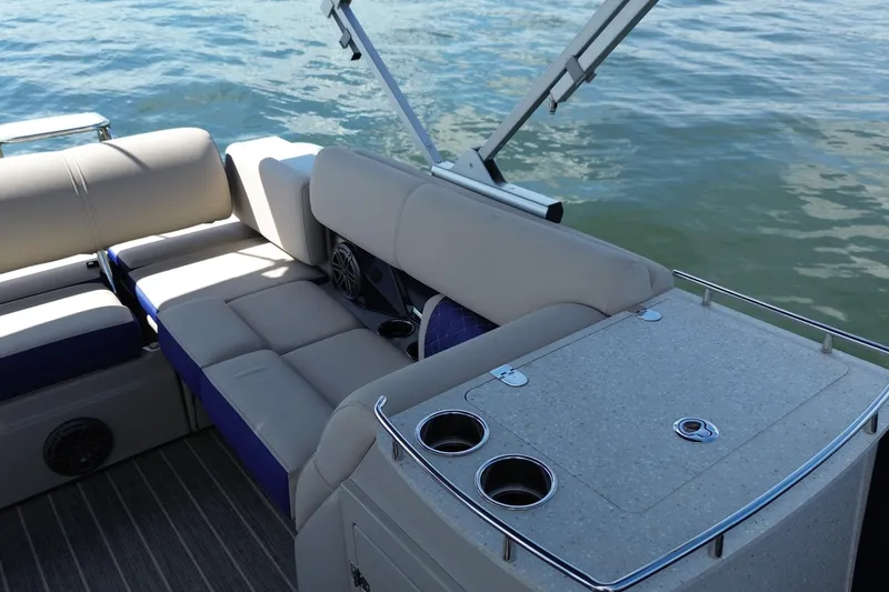 Slide: The Image of 2022 Harris Grand Mariner 250 boat interior with seating and cup holders on water. - 9