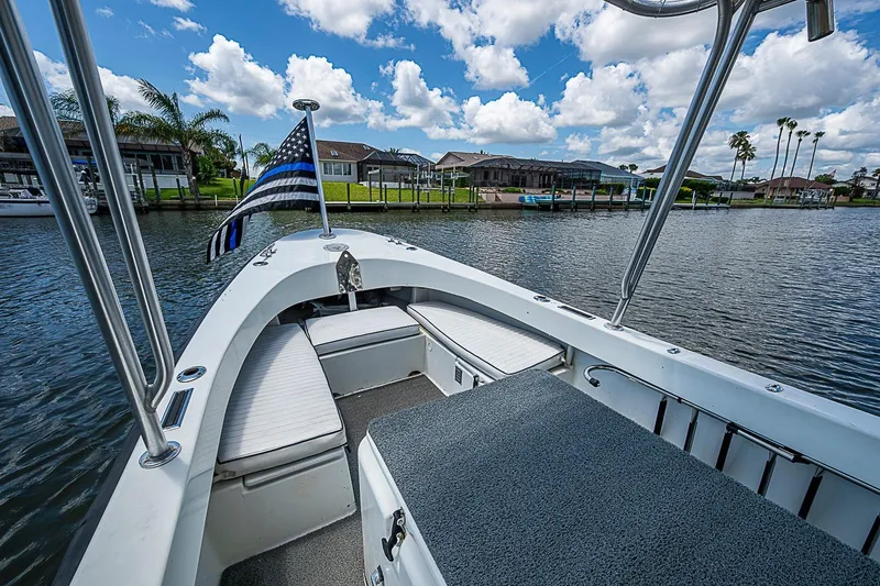 Slide: The Image of Custom 1969 boat with flag on calm water, surrounded by houses and palm trees. - 13