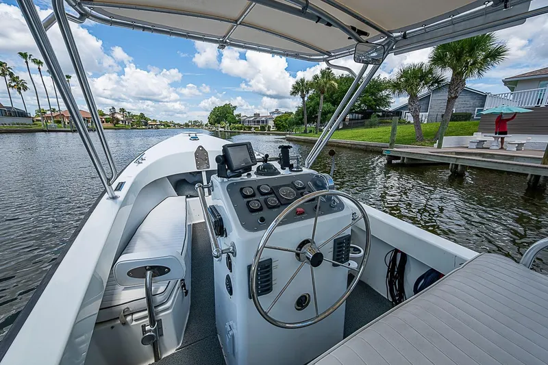 Slide: The Image of Vintage 1969 custom boat on a scenic canal with palm trees and clear skies. - 17