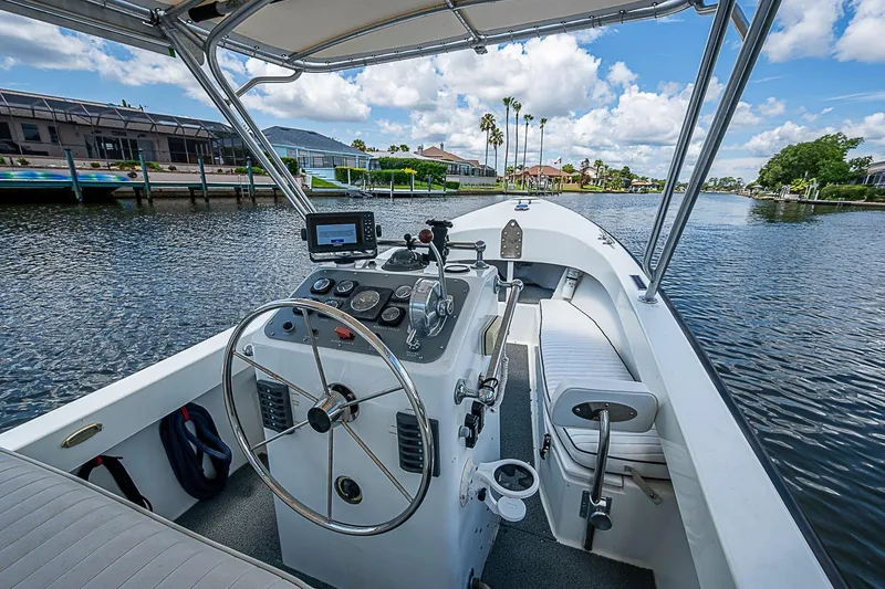 Slide: The Image of 1969 custom boat interior with steering wheel, gauges, and seating on a sunny waterway. - 18
