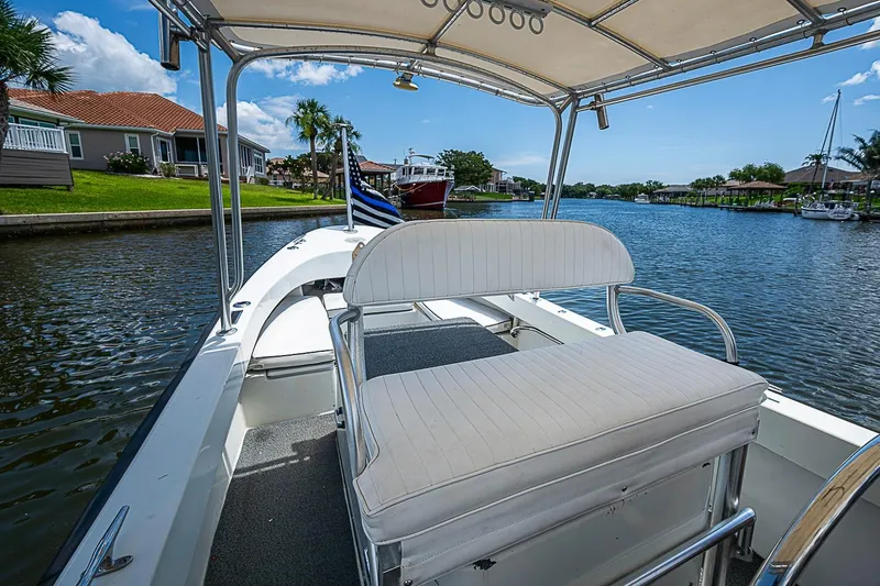 Slide: The Image of Custom 1969 boat with white seating, cruising on a scenic canal under a clear blue sky. - 19