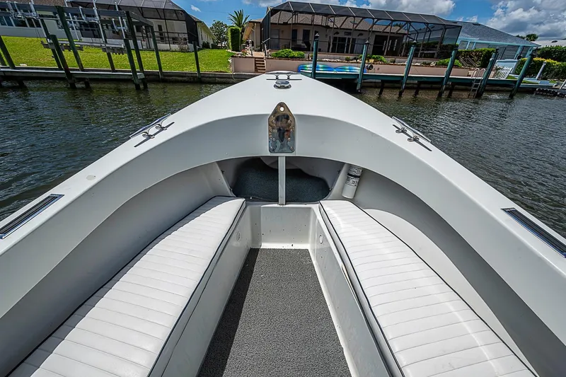 Slide: The Image of Front view of a 1969 custom boat with white seating and waterfront homes. - 23