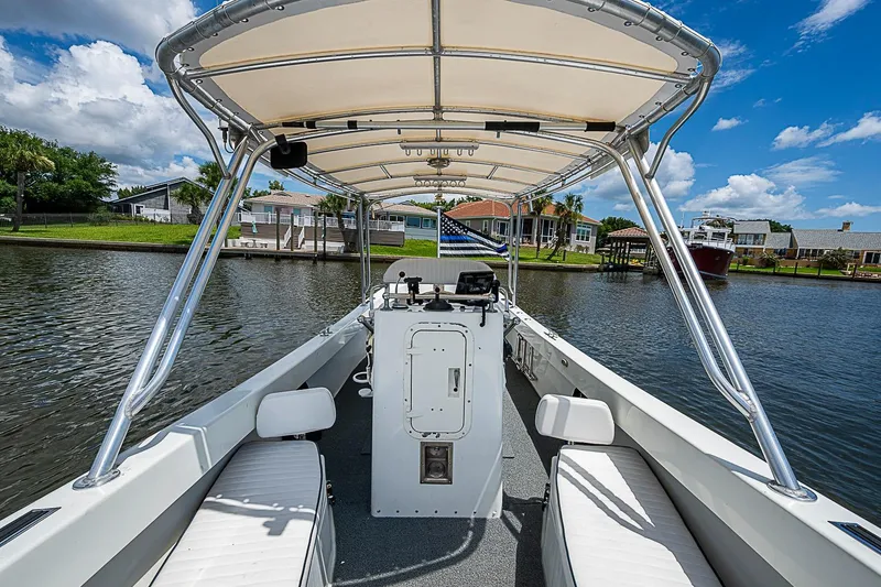 Slide: The Image of Custom 1969 boat with canopy on a calm river, surrounded by waterfront homes. - 24