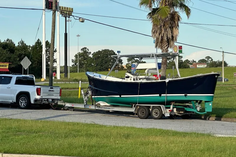 Slide: The Image of A 1997 Ocean Technical Services boat on a trailer, towed by a GMC truck. - 28