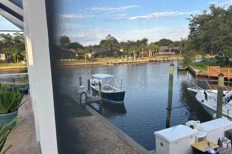 Slide: The Image of Canal view with boats docked, surrounded by lush greenery and residential homes. - 30