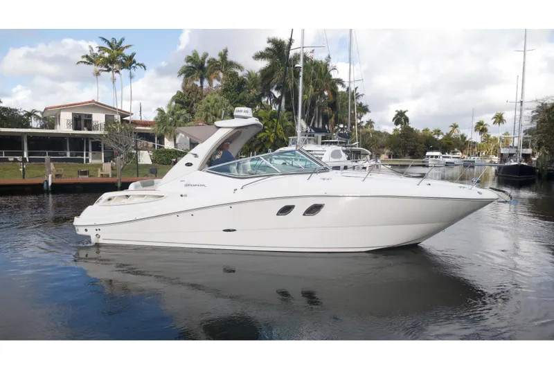 The Image of 2007 Sea Ray Sundancer 310 yacht docked in a scenic marina setting. - 1