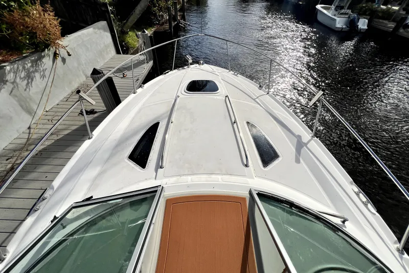 Slide: The Image of 2007 Sea Ray Sundancer 310 boat docked by a serene waterfront. - 14