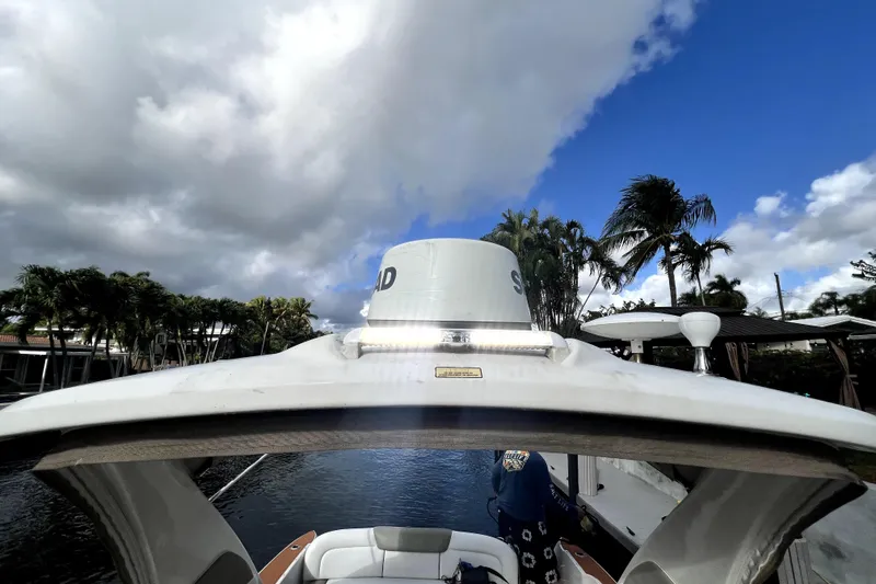 Slide: The Image of 2007 Sea Ray Sundancer 310 boat docked under cloudy sky with palm trees. - 21