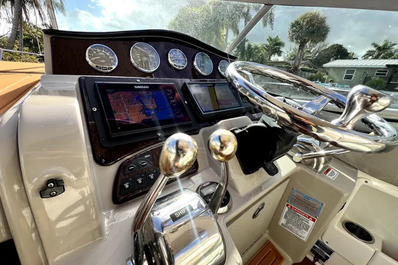 Slide: The Image of 2007 Sea Ray Sundancer 310 helm with navigation system and chrome steering wheel. - 26