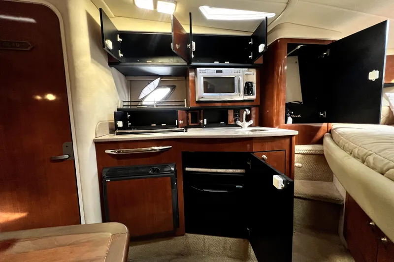 Slide: The Image of Interior of 2007 Sea Ray Sundancer 310 yacht with open cabinets and kitchenette. - 28