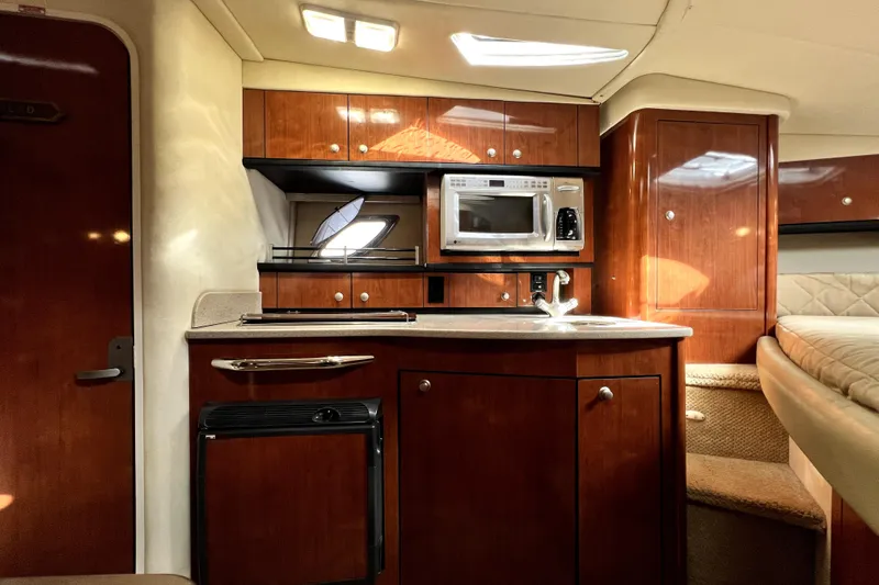 Slide: The Image of Luxurious 2007 Sea Ray Sundancer 310 cabin interior with kitchenette and wood finish. - 29