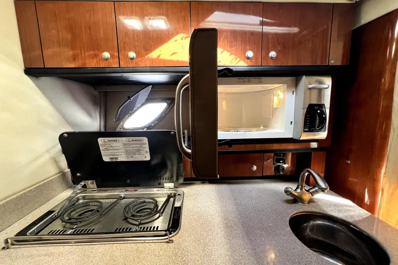 Slide: The Image of 2007 Sea Ray Sundancer 310 galley with stove, microwave, and sink. - 34
