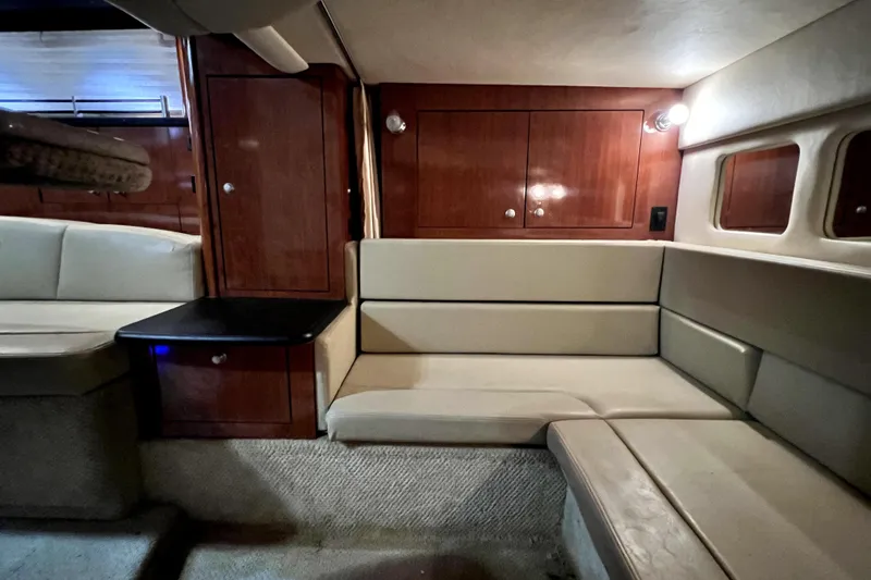 Slide: The Image of Interior of 2007 Sea Ray Sundancer 310, featuring beige seating and wooden cabinetry. - 39