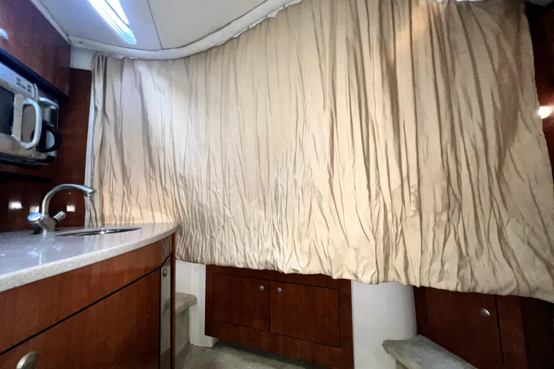 Slide: The Image of 2007 Sea Ray Sundancer 310 interior with kitchenette, sink, microwave, and beige curtain. - 41