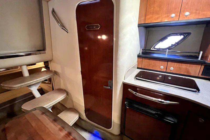 Slide: The Image of 2007 Sea Ray Sundancer 310 interior with kitchenette, stairs, and wooden cabinetry. - 42
