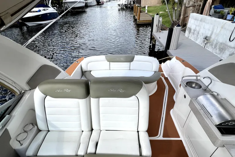 Slide: The Image of 2007 Sea Ray Sundancer 310 boat interior with seating and kitchenette by a dock. - 51