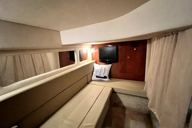 Slide: The Image of Interior cabin of 2007 Sea Ray Sundancer 310 with seating, TV, and wooden cabinetry. - 55