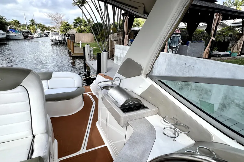 Slide: The Image of 2007 Sea Ray Sundancer 310 boat interior with seating and outdoor kitchen by a dock. - 60