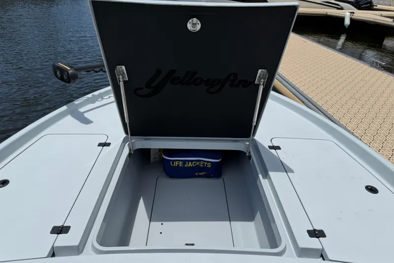 Slide: The Image of 2017 Yellowfin 24 Bay CE boat storage compartment with life jackets visible. - 13