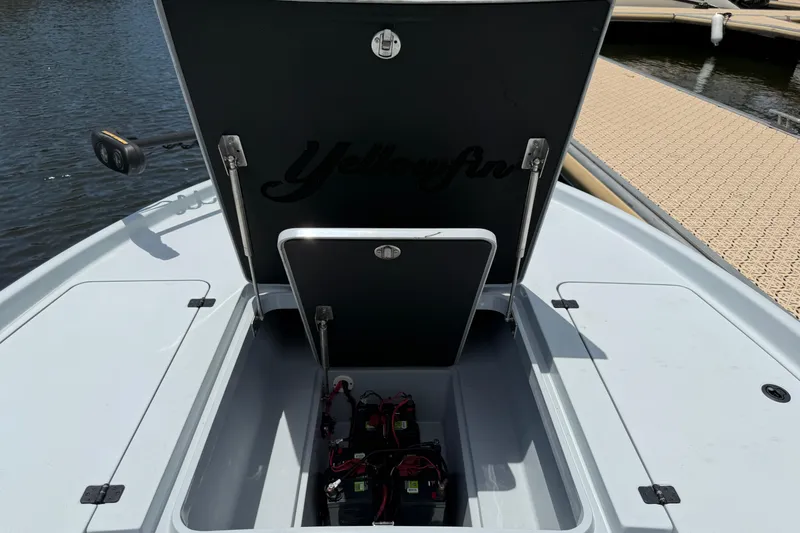 Slide: The Image of 2017 Yellowfin 24 Bay CE boat battery compartment open by the dock. - 14