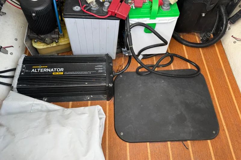 Slide: The Image of 2017 Yellowfin 24 Bay CE boat alternator and battery setup on wooden deck. - 24