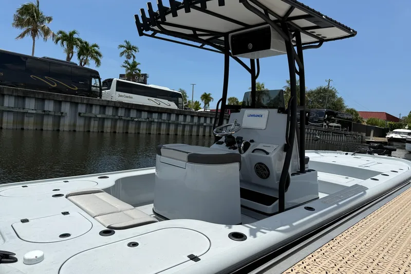Slide: The Image of 2017 Yellowfin 24 Bay CE boat docked by a canal with palm trees. - 3