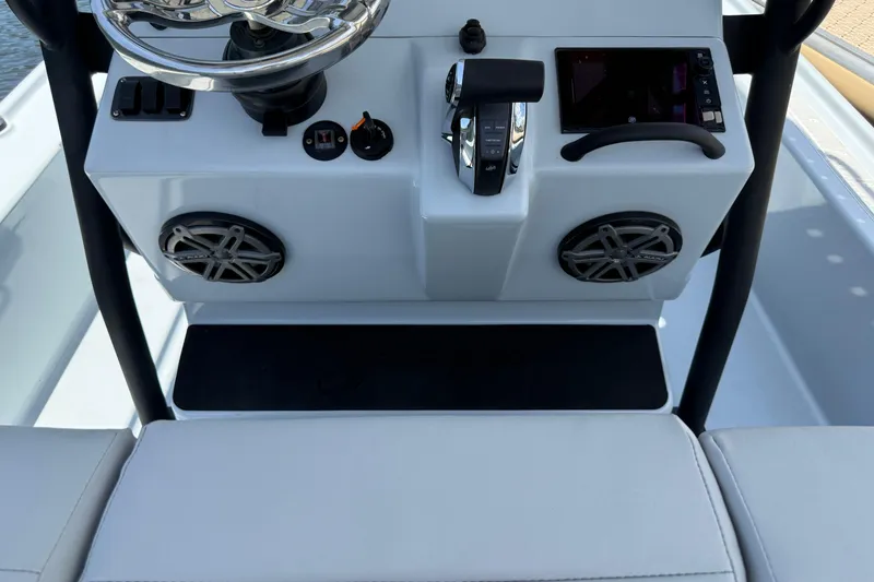 Slide: The Image of 2017 Yellowfin 24 Bay CE boat console with steering wheel, controls, and speakers. - 32