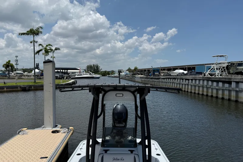 Slide: The Image of 2017 Yellowfin 24 Bay CE boat docked at a marina under a partly cloudy sky. - 5