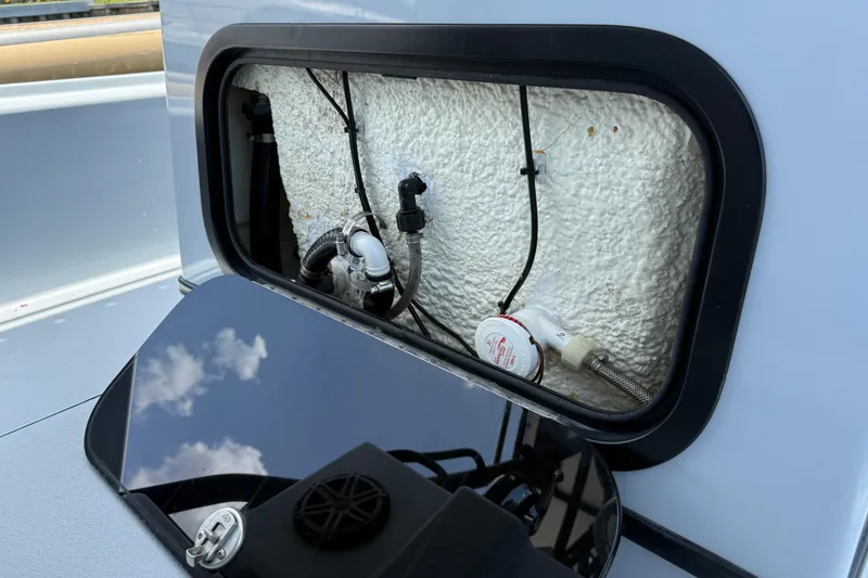 Slide: The Image of 2017 Yellowfin 24 Bay CE boat compartment with plumbing and wiring details. - 56