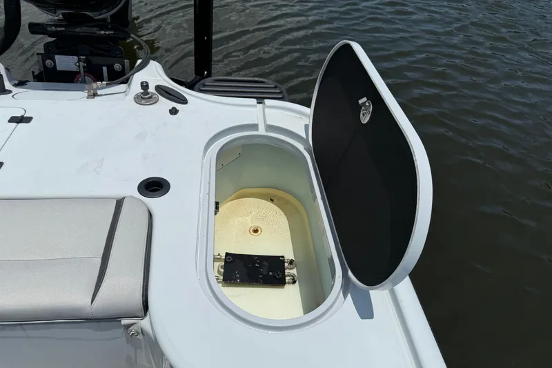 Slide: The Image of Open storage compartment on 2017 Yellowfin 24 Bay CE boat by the water. - 59