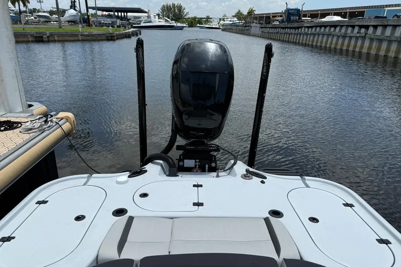 Slide: The Image of 2017 Yellowfin 24 Bay CE boat docked, rear view with motor and calm water. - 6