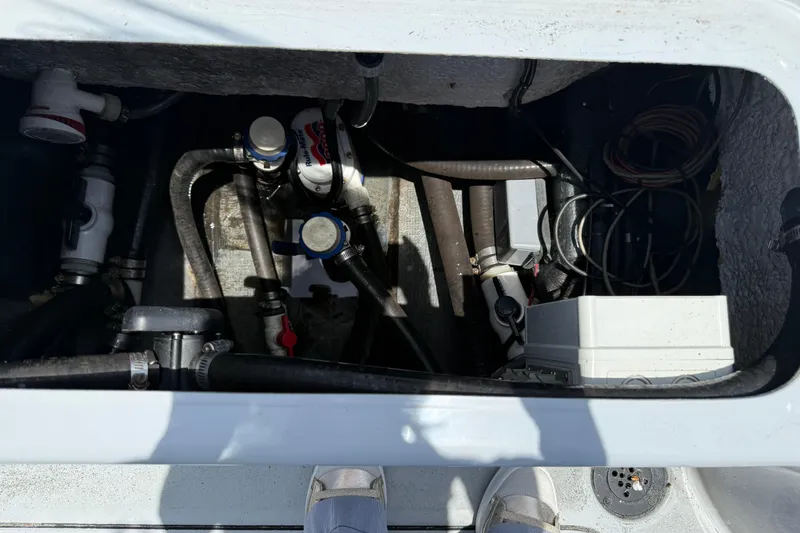 Slide: The Image of 2017 Yellowfin 24 Bay CE boat compartment with pumps, hoses, and wiring. - 65