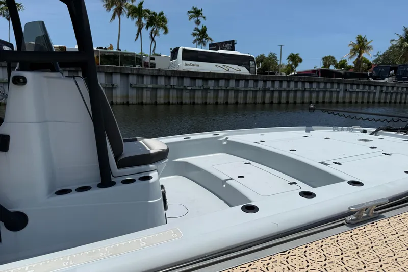 Slide: The Image of 2017 Yellowfin 24 Bay CE boat docked by a canal with palm trees in the background. - 7