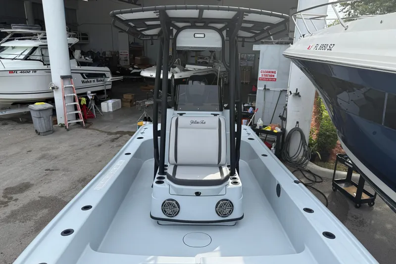 Slide: The Image of 2017 Yellowfin 24 Bay CE boat in a marina, surrounded by other vessels and equipment. - 70