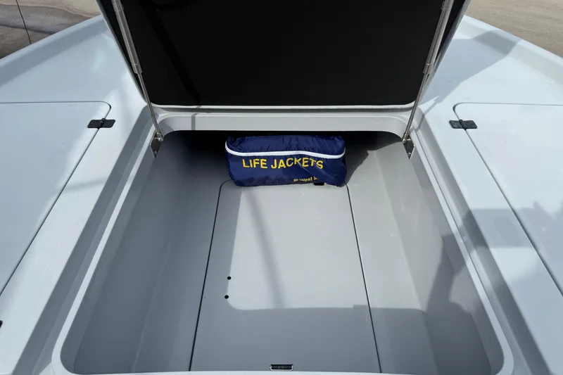 Slide: The Image of Open storage compartment on 2017 Yellowfin 24 Bay CE boat with life jackets. - 79
