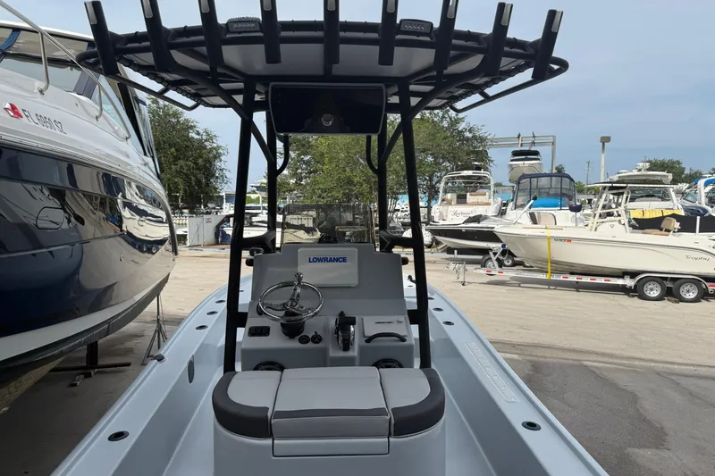 Slide: The Image of 2017 Yellowfin 24 Bay CE boat interior with steering console and seating, docked among other boats. - 95