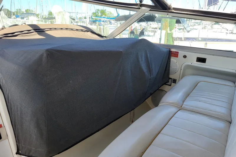 Slide: The Image of Interior of a 1995 Sea Ray Sundancer 370 with covered dashboard and white seating. - 12
