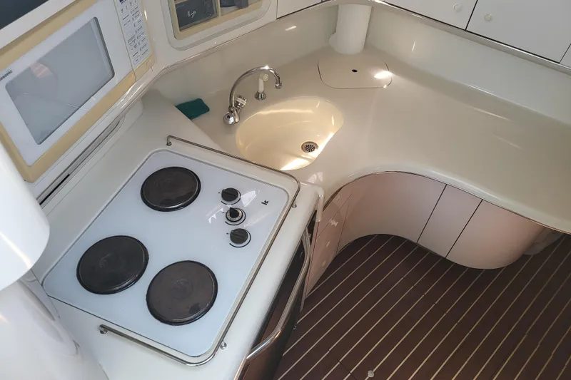 Slide: The Image of Compact kitchen area in a 1995 Sea Ray Sundancer 370 yacht with stove and sink. - 13