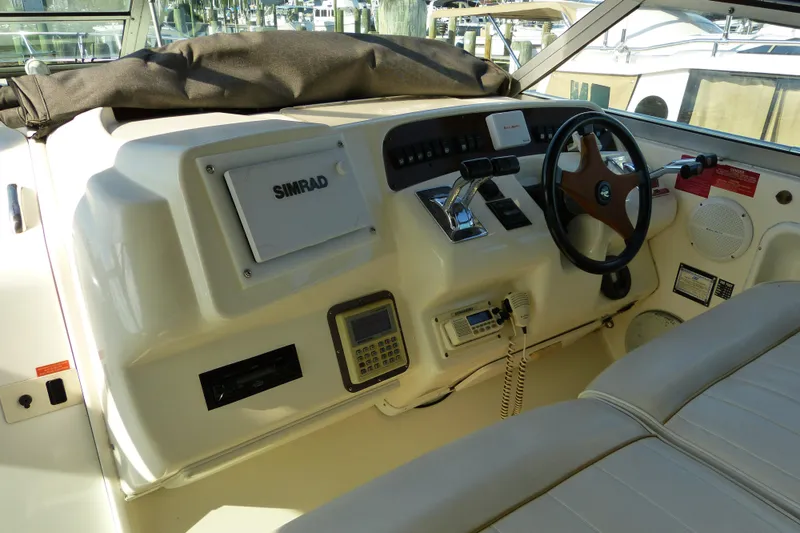 Slide: The Image of 1995 Sea Ray Sundancer 370 helm with Simrad navigation system and classic steering wheel. - 2