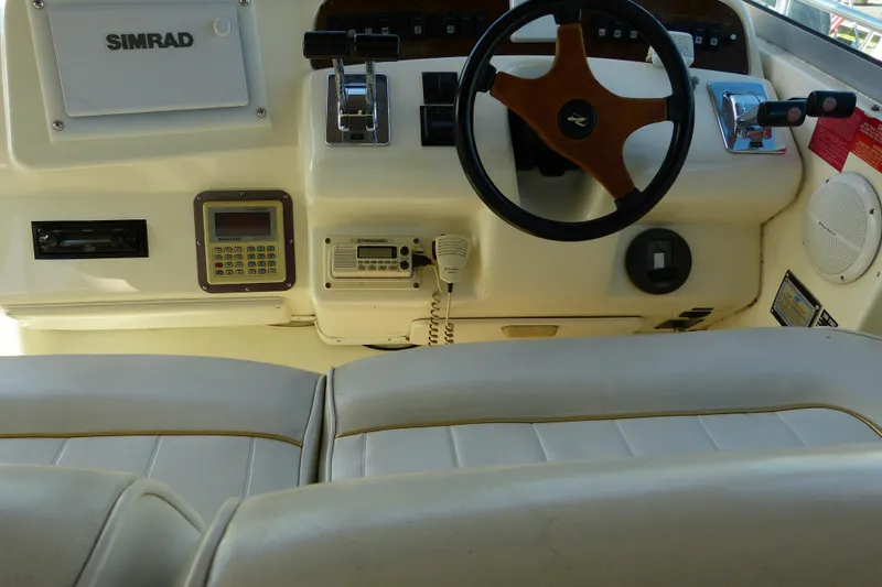 Slide: The Image of 1995 Sea Ray Sundancer 370 helm with steering wheel, Simrad electronics, and control panel. - 34