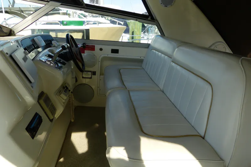Slide: The Image of 1995 Sea Ray Sundancer 370 cockpit with white leather seating and steering controls. - 35