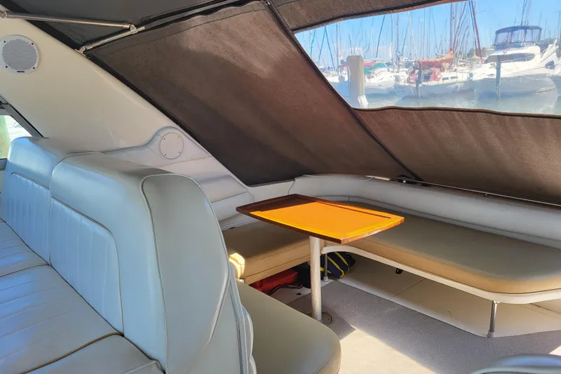 Slide: The Image of Interior of a 1995 Sea Ray Sundancer 370 with beige seating and wooden table. - 4