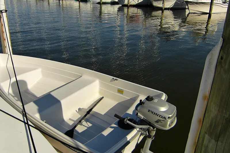 Slide: The Image of Small boat with Honda outboard motor docked on calm water. - 57