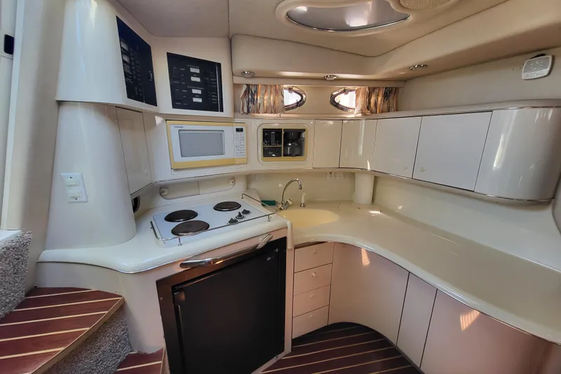 Slide: The Image of 1995 Sea Ray Sundancer 370 yacht kitchen with stove, microwave, and cabinets. - 7