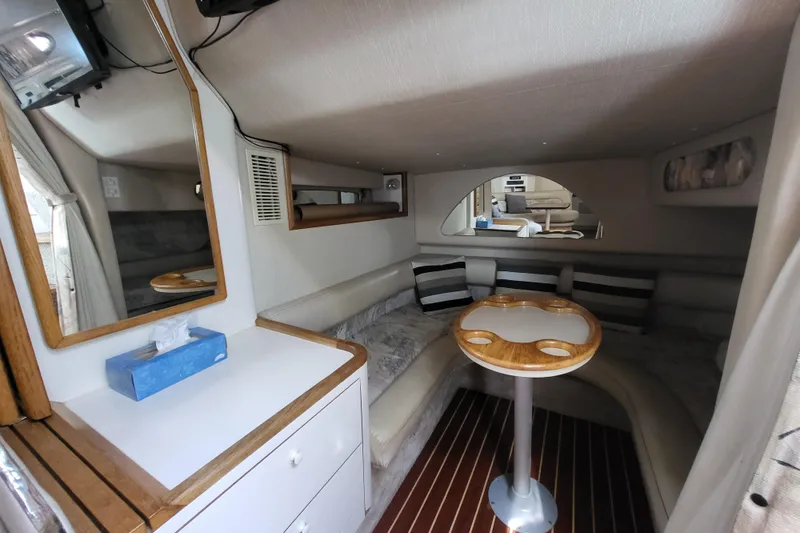 Slide: The Image of Interior of a 1995 Sea Ray Sundancer 370 with cozy seating and wooden table. - 9