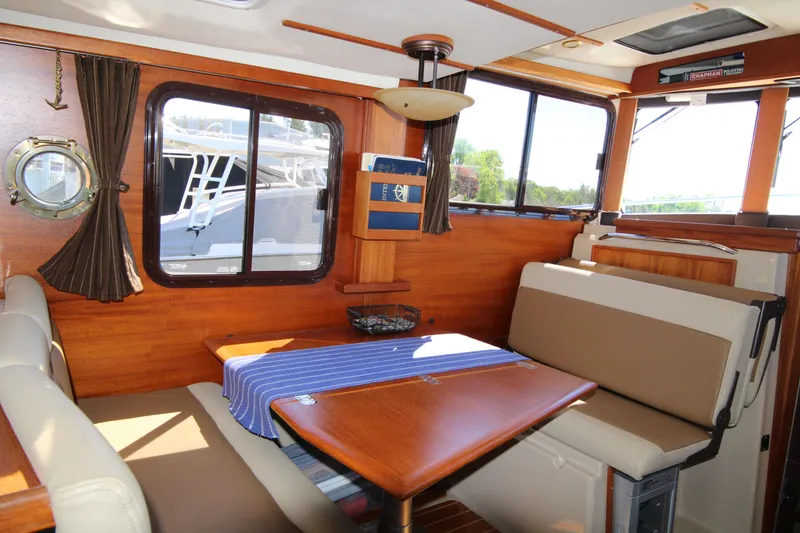 Slide: The Image of Interior of 2013 Ranger Tugs R-31 CB with wooden dining area and blue tablecloth. - 13
