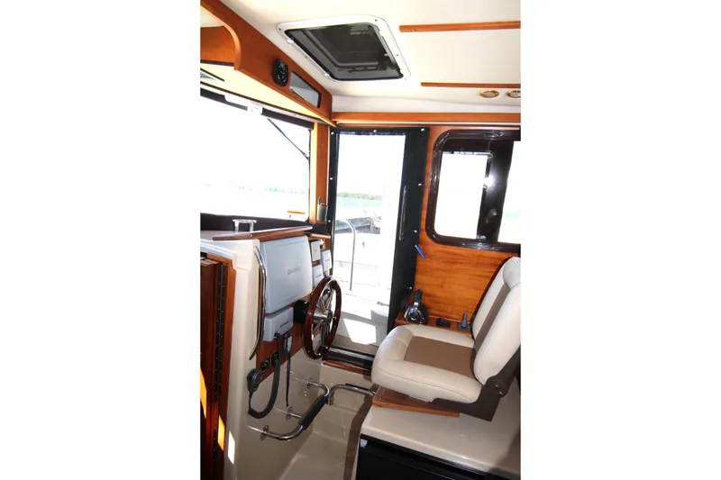 Slide: The Image of Interior of 2013 Ranger Tugs R-31 CB boat, featuring helm and seating area. - 14
