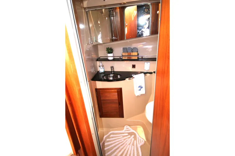 Slide: The Image of 2013 Ranger Tugs R-31 CB bathroom with sink, mirror, and wooden accents. - 25